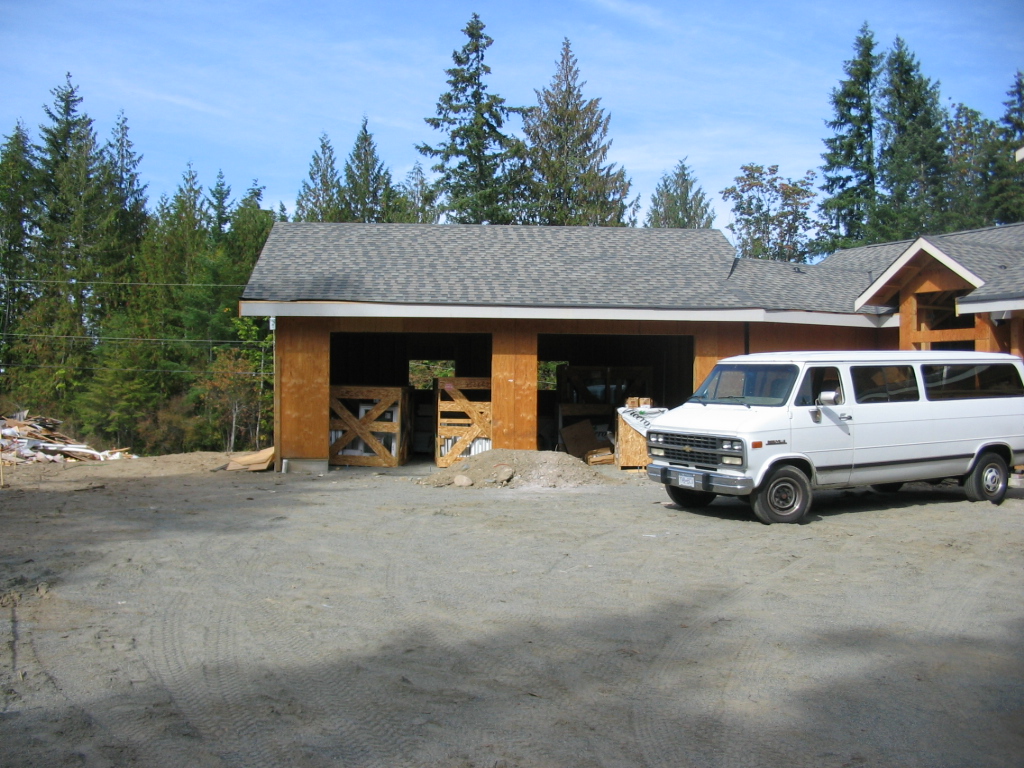 Building under construction with completed roof and garage framing