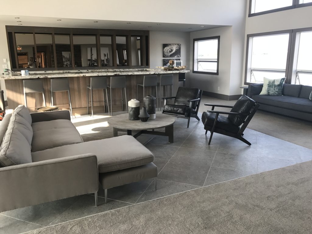 Modern finished living space with custom bar and large windows